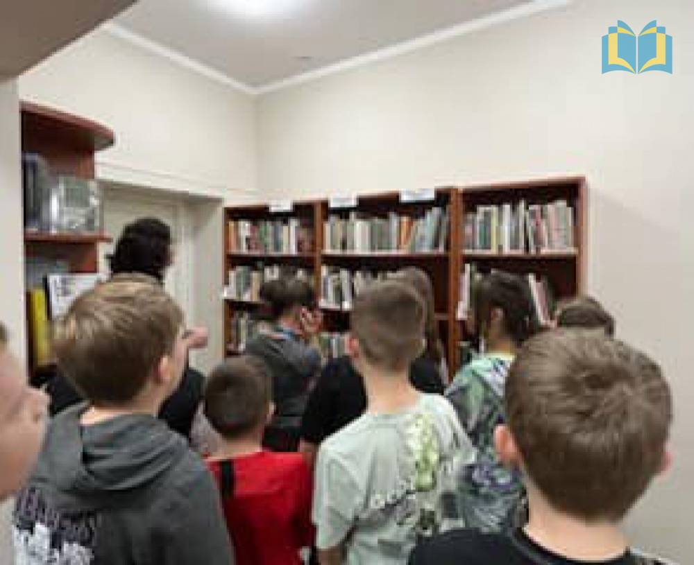 Zdjęcie: Dzieci wraz z bibliotekarzem zwiedzają bibliotekę, poznają księgozbiór i zasady wyszukiwania zbiorów.